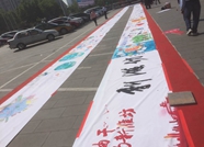 潍坊举行庆“五·一”鲜花送劳模暨千人彩绘百米长卷活动