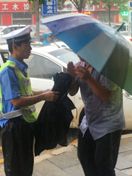 感动！滨州骑警雨中脱下雨衣 护送高烧男童就医