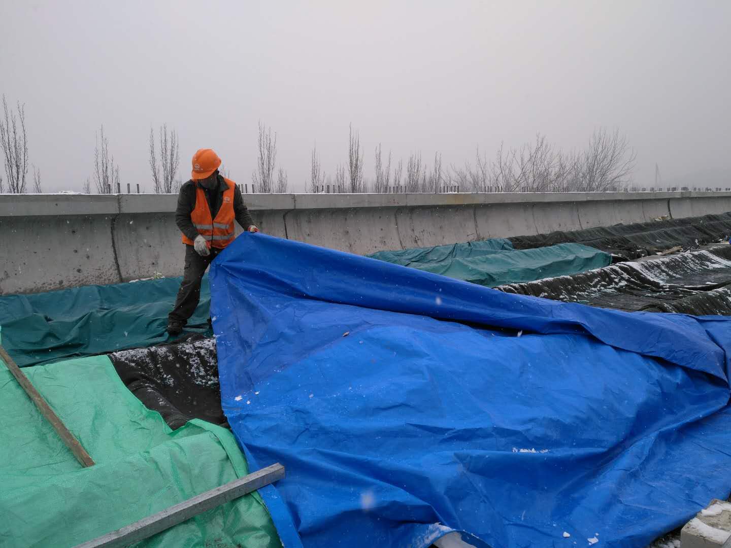 济南R1线雪中施工：钢轨盖“棉被”工人笑着说干活就暖和了