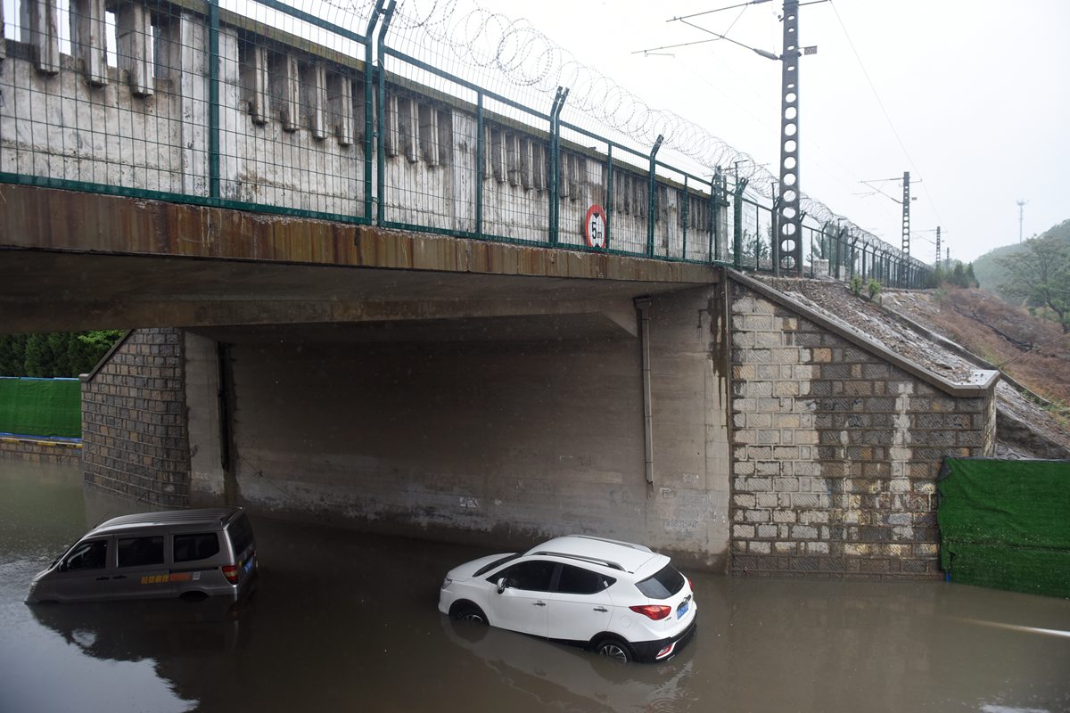 济南一铁路桥下积水严重 三辆私家车抛锚水中