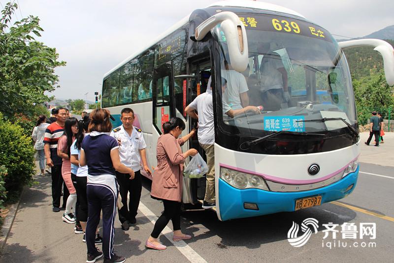 6月18日，在卧龙村公交站，乘客排队乘坐639路公交车去北九水游玩。_副本.jpg