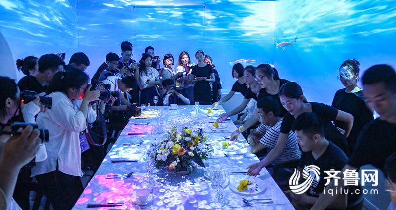 齐鲁网青岛7月29日讯 青岛啤酒节,醉美西海岸。现代科技的发展已经渗透到人们的衣食住行当中,在第28届青岛国际啤酒节上,金沙滩啤酒城内藏着一家全息餐厅西岛艺术料理。金沙滩啤酒城的西岛艺术料理不仅拥有独特设计的菜品,抓住食客的舌尖,更让食客流连忘返的是它的环境氛围,在这里品尝美味佳肴的同时,全息投影也会带给你沉浸式体验,一道菜一个主题,给人回归自然之感。 在金沙滩啤酒城东侧一处特别显眼的木屋便是这家餐厅,西岛艺术料理共有3间标间,名字也是相当接地气:金沙滩,西海岸和琅琊岛,彰显了西海岸特色。