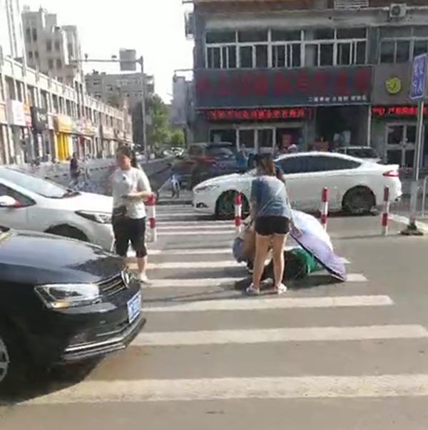 正能量｜淄博：女子过马路被撞倒地 市民撑伞全程陪护