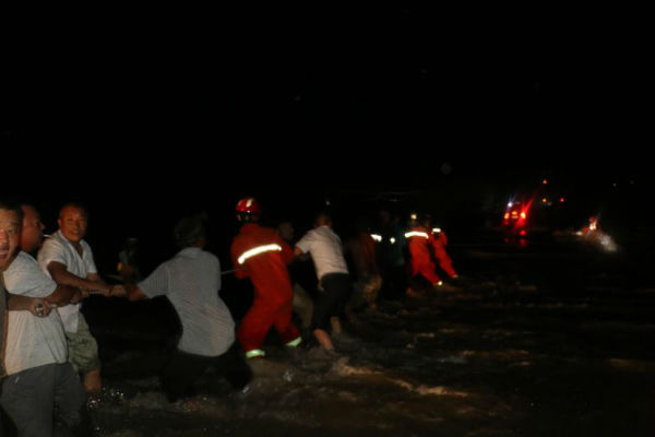 日照一轿车过桥被暴涨洪水围困 警民合力救出司机