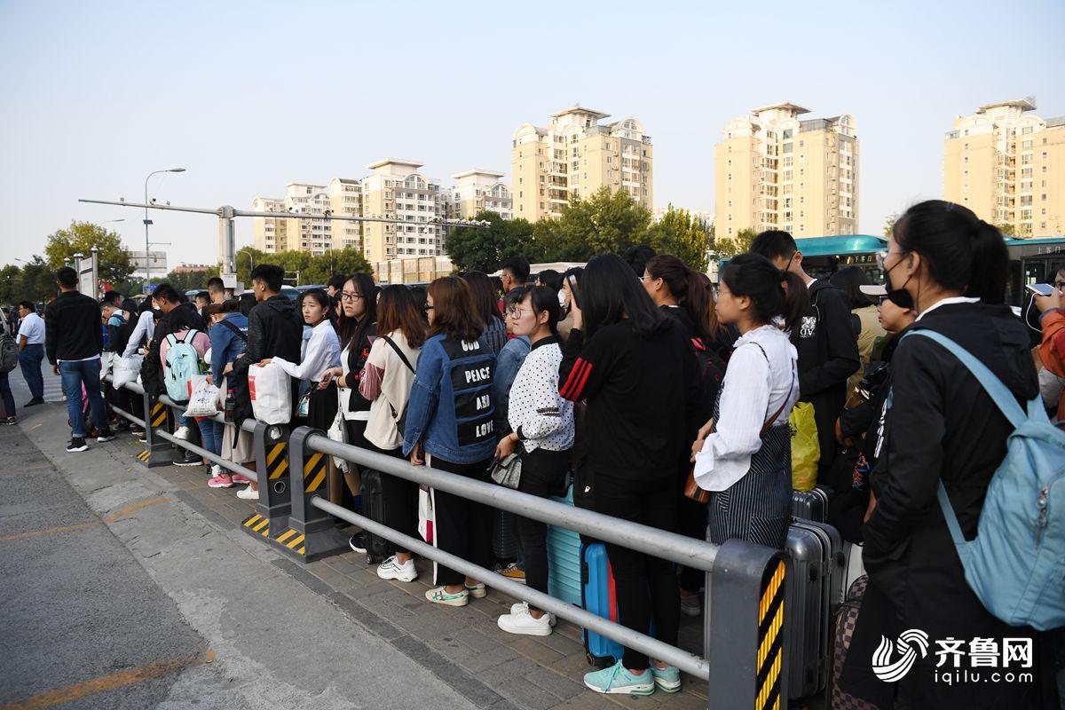 图为排队等待巴士的学生.