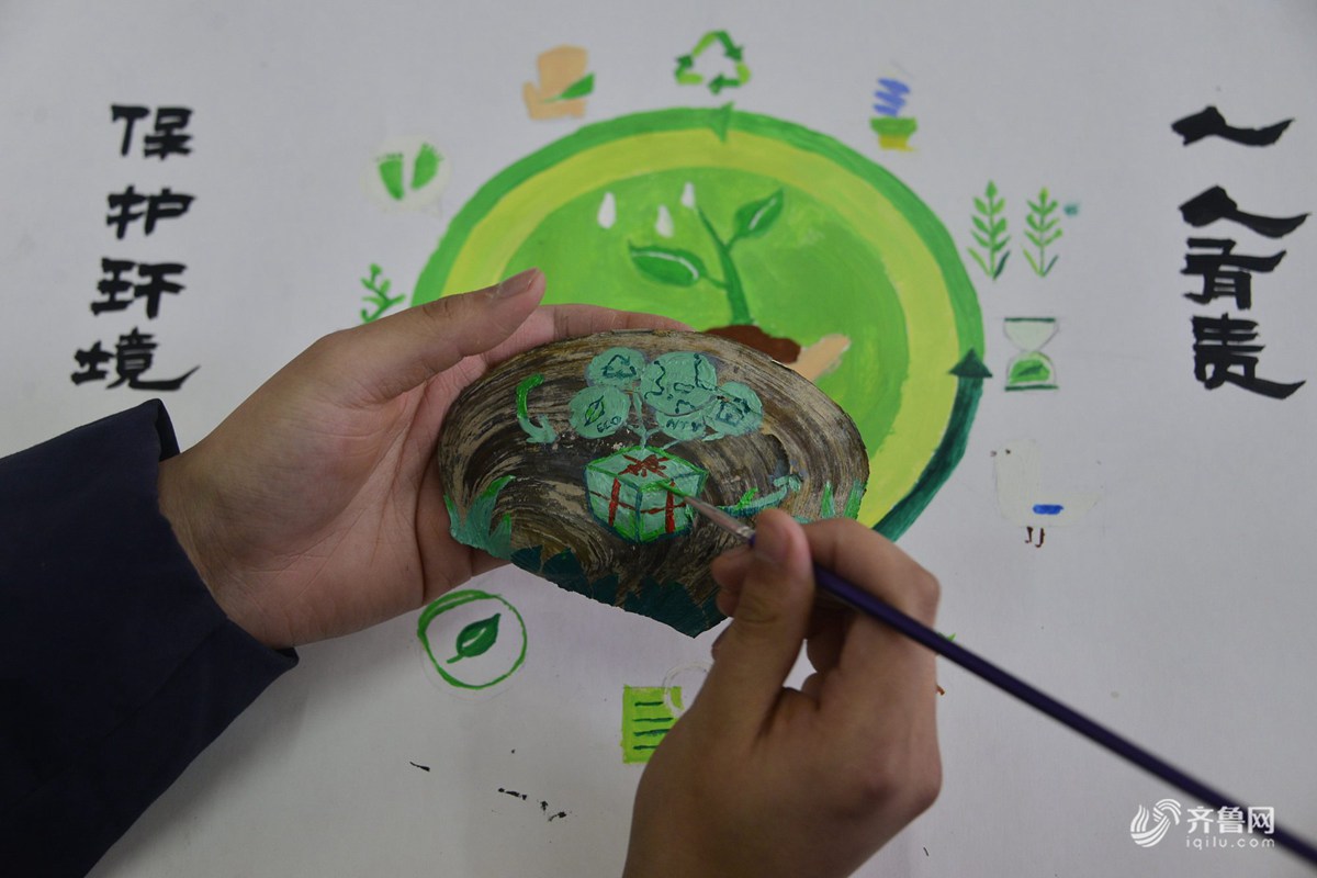 在山东聊城大学拍摄的大学生们在河蚌壳上彩绘的环保主题绘画作品