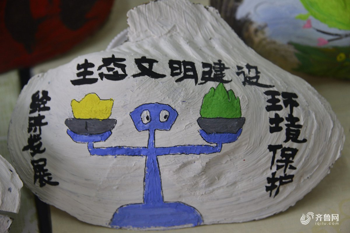 在山东聊城大学拍摄的大学生们在河蚌壳上彩绘的环保主题绘画作品