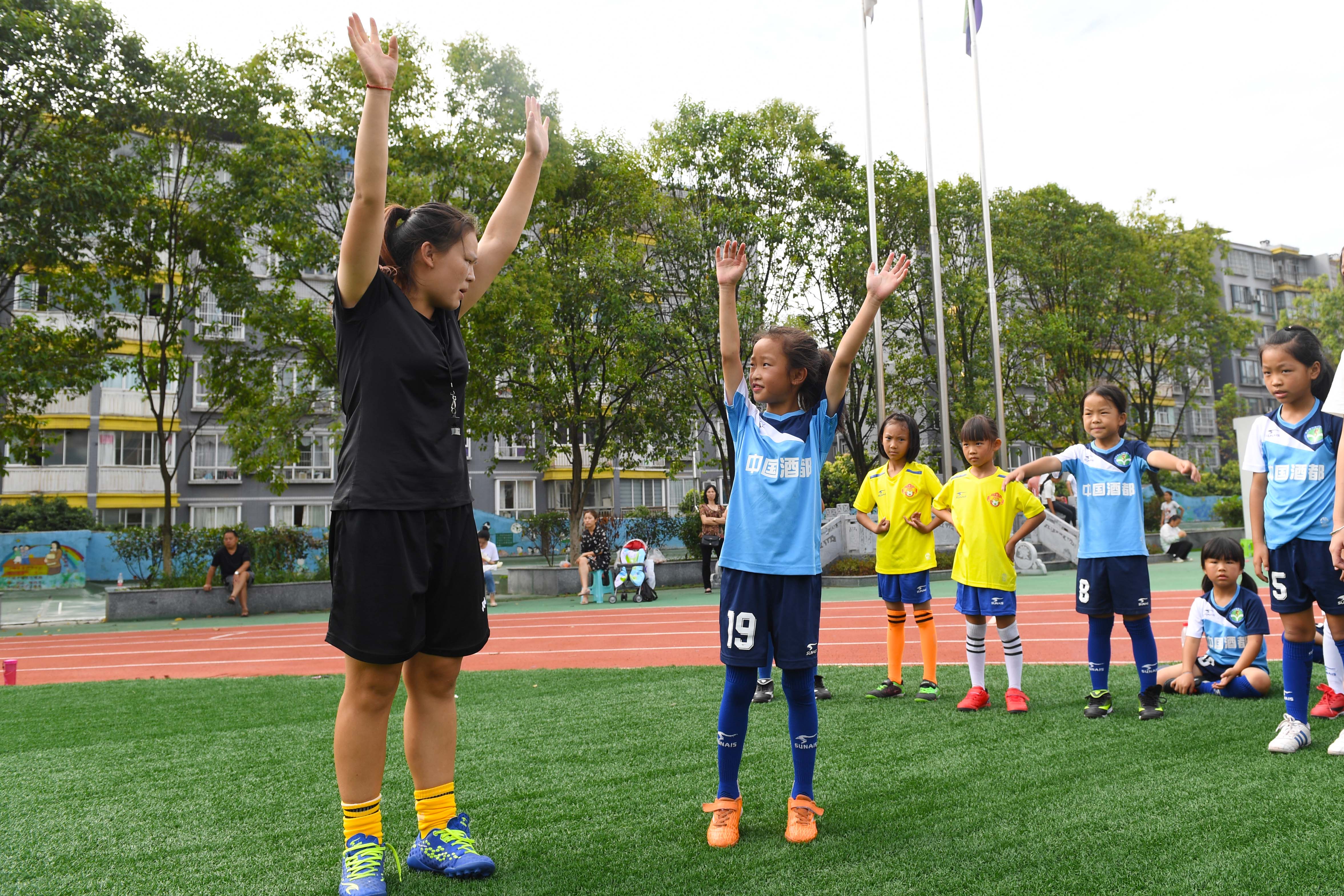 8月9日,在仁怀市实验小学足球场内,该校一年级女子足球队的队员在