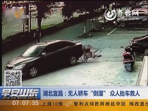 湖北宜昌：”无人轿车“倒溜” 众人抬车救人