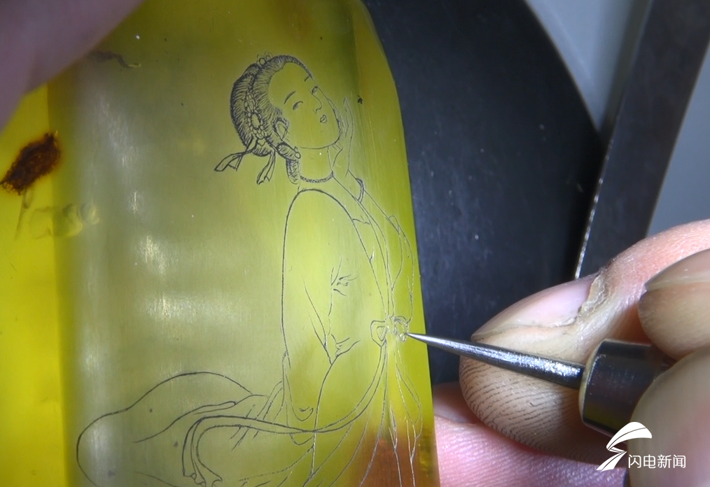 记者见到王子明的时候,他正专心致志地在琥珀上雕刻着一幅仕女图.