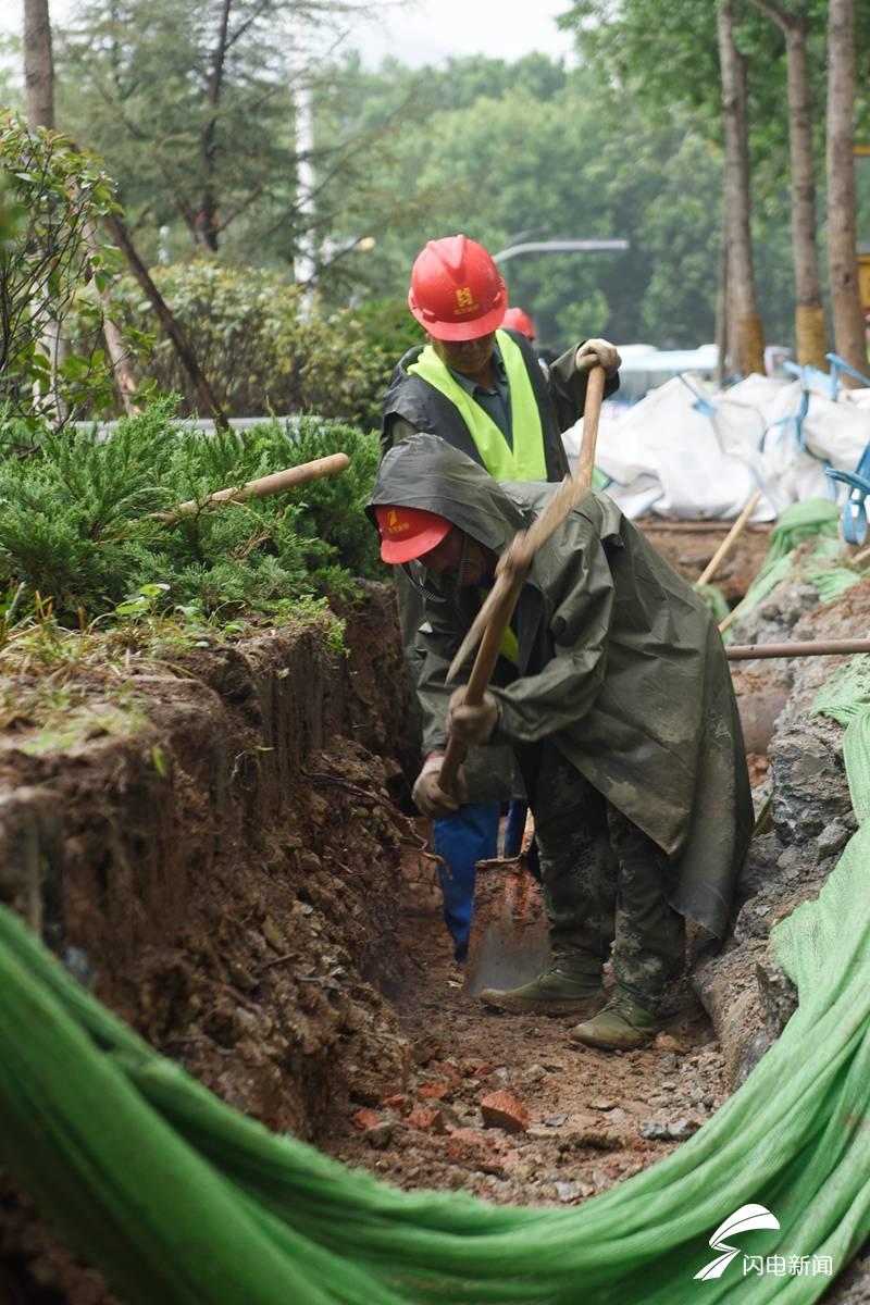 济南马鞍山路上施工的工人,尽早的打通道路,他们雨天不停歇.