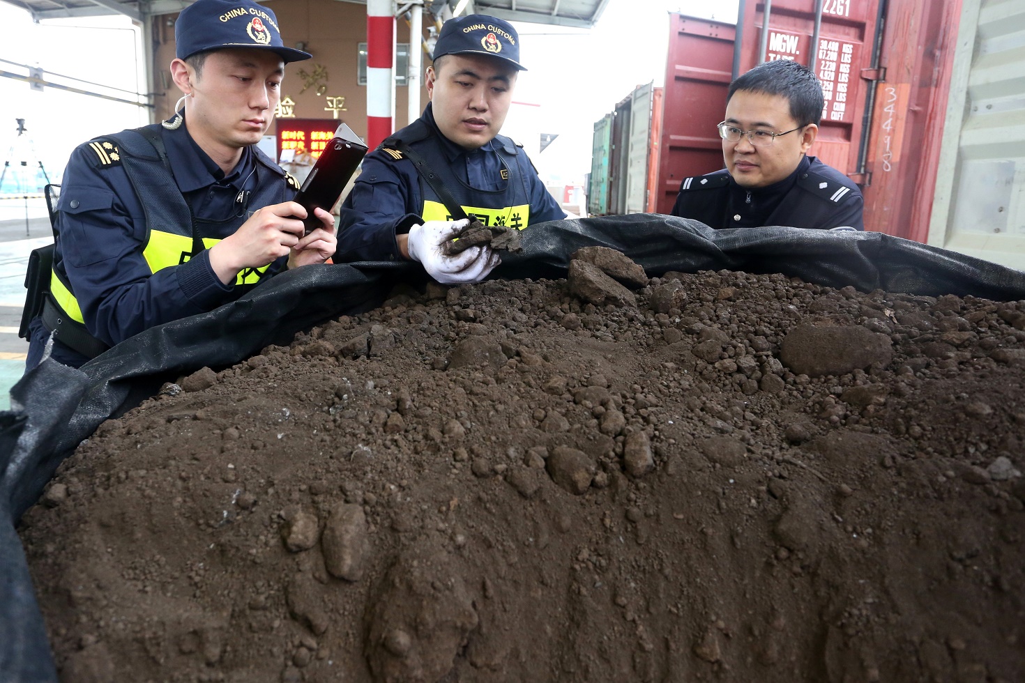 圖為：青島海關關警員對走私進口固體廢物進行查驗取證 鄭長江攝.jpg