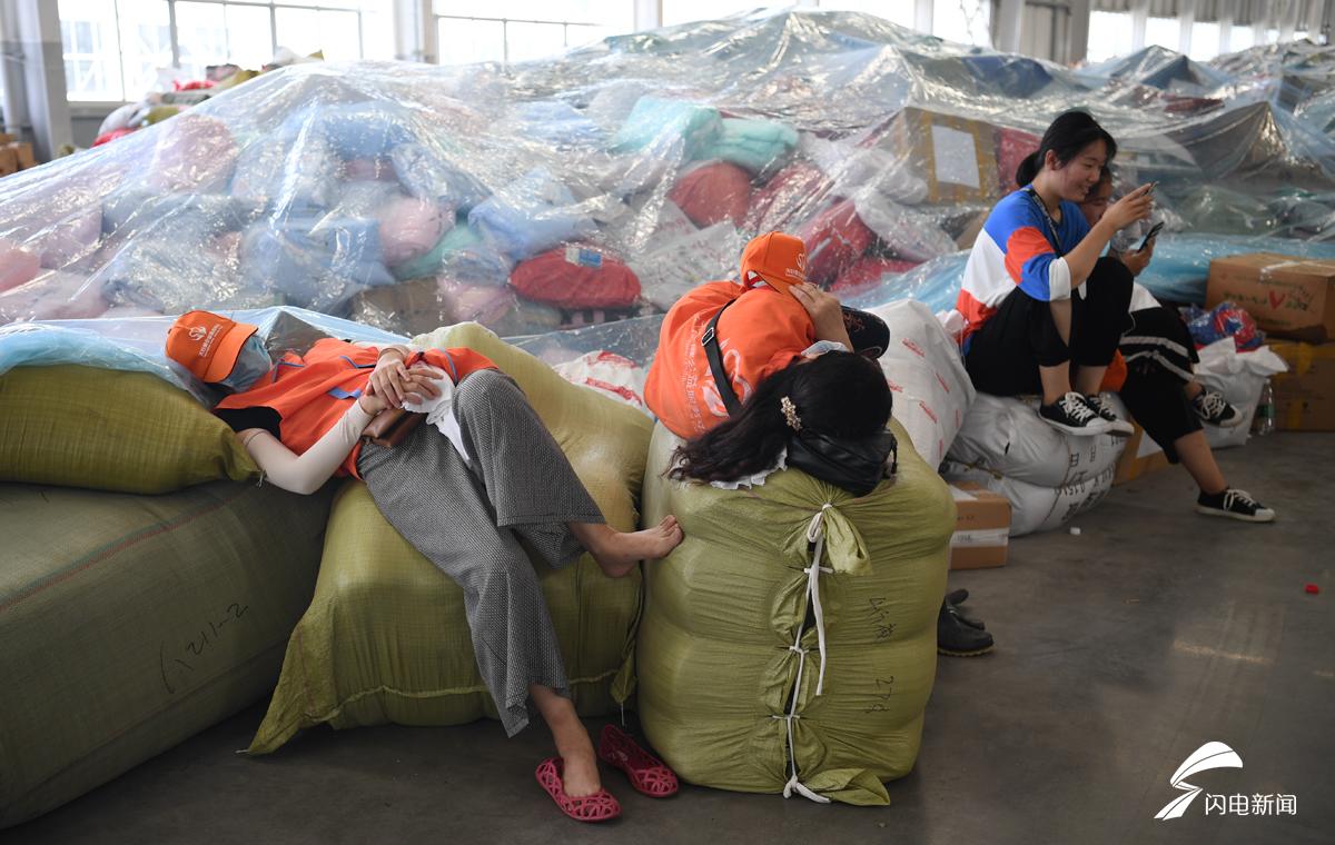 镜头记录抗灾一线志愿者奔波忙碌的最美身影