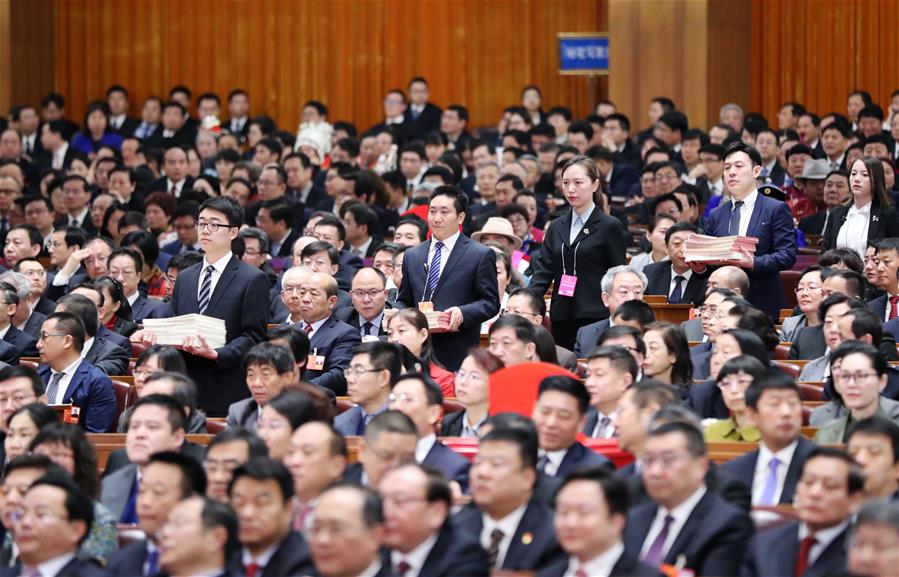 3月17日，十三届全国人大一次会议在北京人民大会堂举行第五次全体会议。这是工作人员准备发放选票。 新华社记者 刘卫兵 摄.jpg