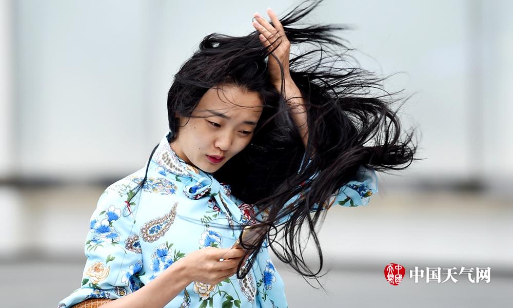 成都气温下降美女街头迎战大风