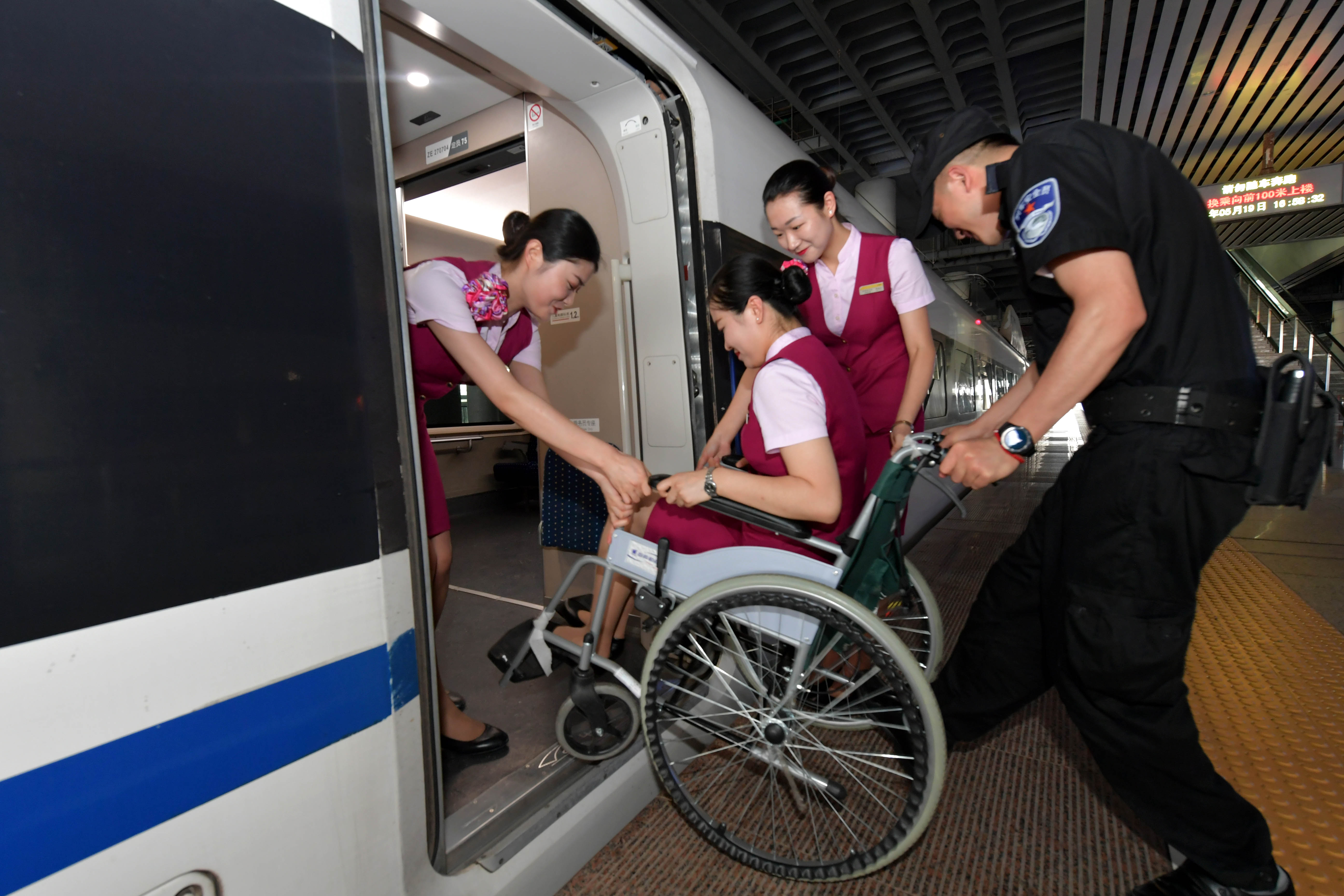 5月19日,在南昌客运段的一趟列车上,乘务人员在体验残疾人乘坐轮椅