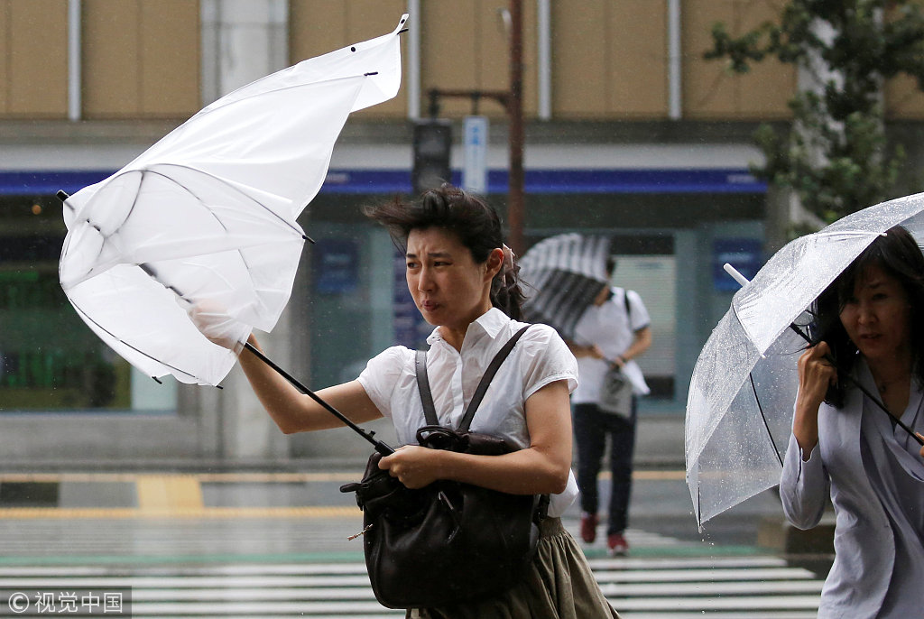 日本东京,台风"姗姗"逼近日本,民众用雨伞抵挡暴雨和大风