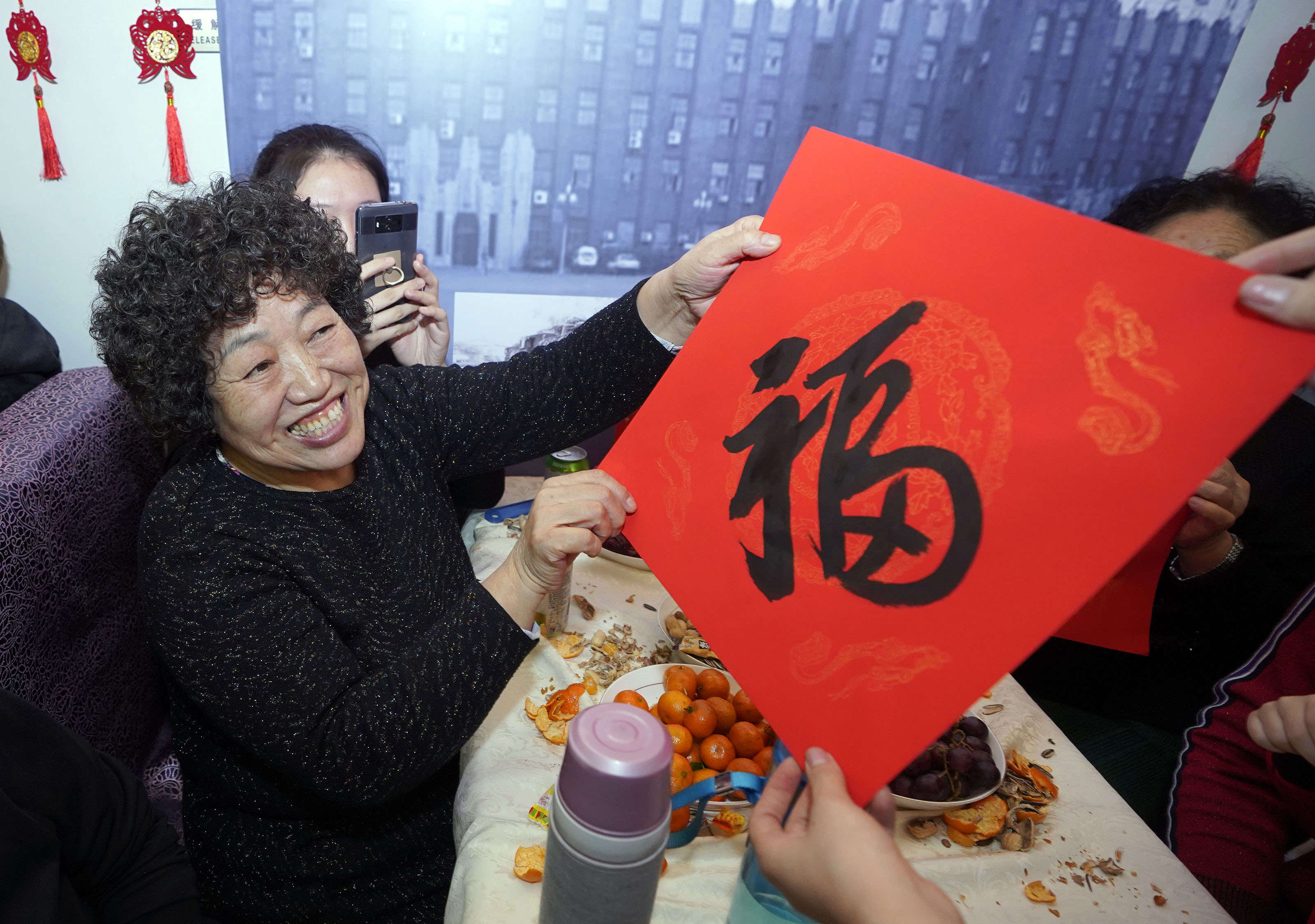 在t48次列车上举行的"回家过年"春晚上,一名旅客接过乘务人员送的福字