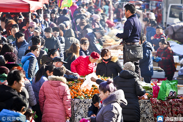 2019年1月24日,山东威海毕家疃年货大集,居民带着孩子赶年集,找年味.