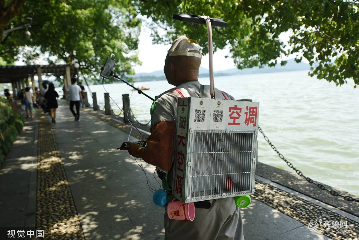 在杭州,游客背着"空调"直播酷暑中的西湖.